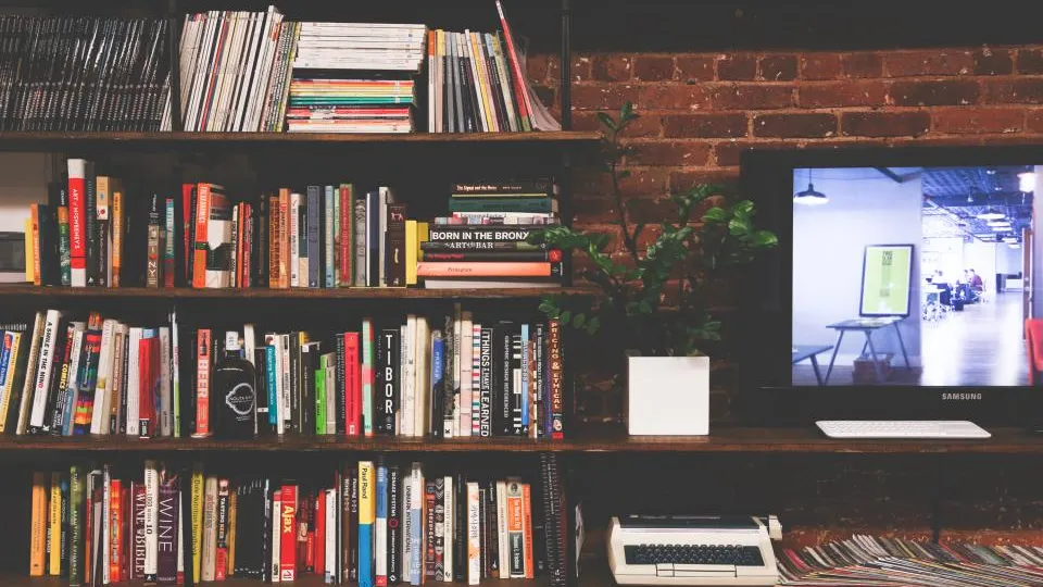 A wall of bookshelves next to a small screen